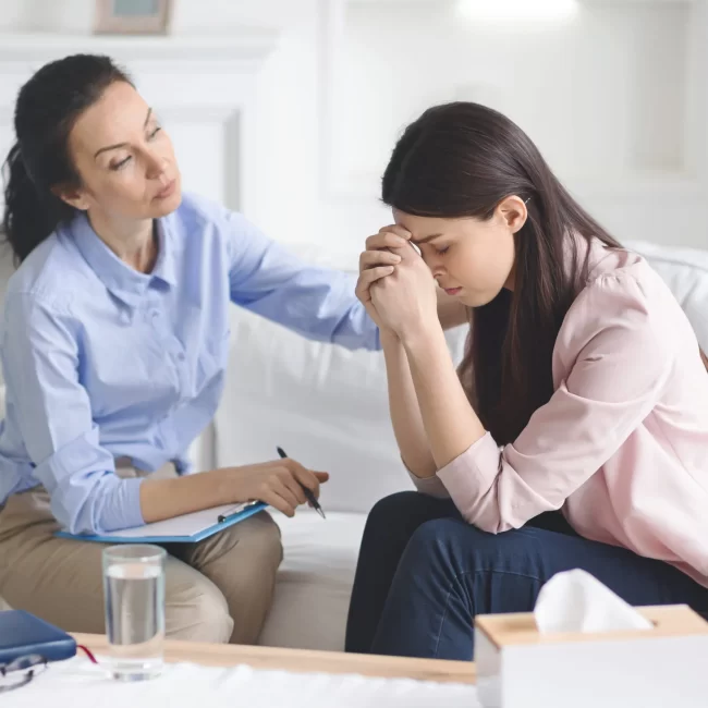 therapist-comforting-her-depressed-crying-woman-MGHJJ6H-scaled-1